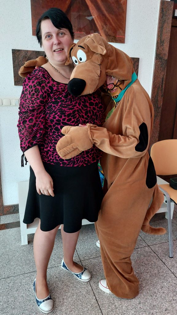 Wspólne zdjęcie na sali integracyjno - zabawowej mieszkanki wraz z opiekunką w stroju Scooby Doo.                   