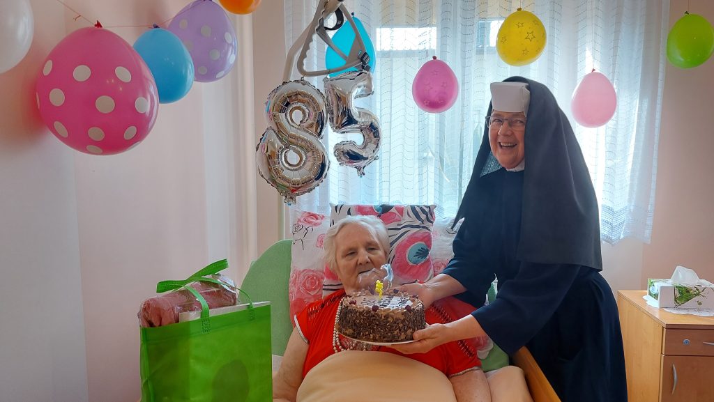 Siostra Albertynka z tortem przy jubilatce.