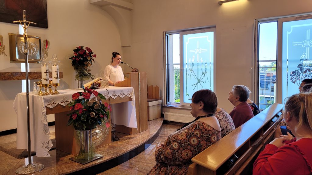 Msza święta w kaplicy Domu, mieszkanki siedzą zasłuchane i wpatrzone w osobę czytającą przy ambonce